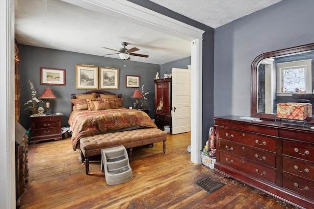 bedroom featuring a textured ceiling, ceiling fan, and light wood-type flooring