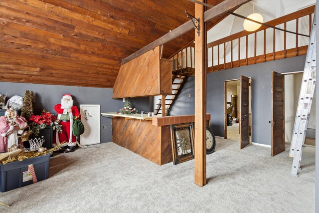 interior space featuring light carpet, wooden ceiling, kitchen peninsula, and lofted ceiling with beams