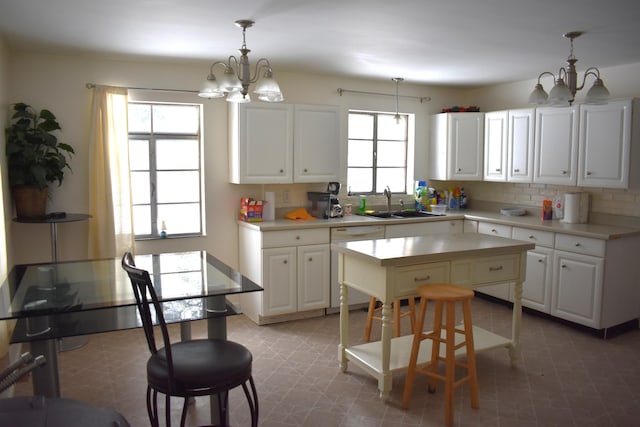 kitchen with pendant lighting, white cabinets, a chandelier, and a kitchen island