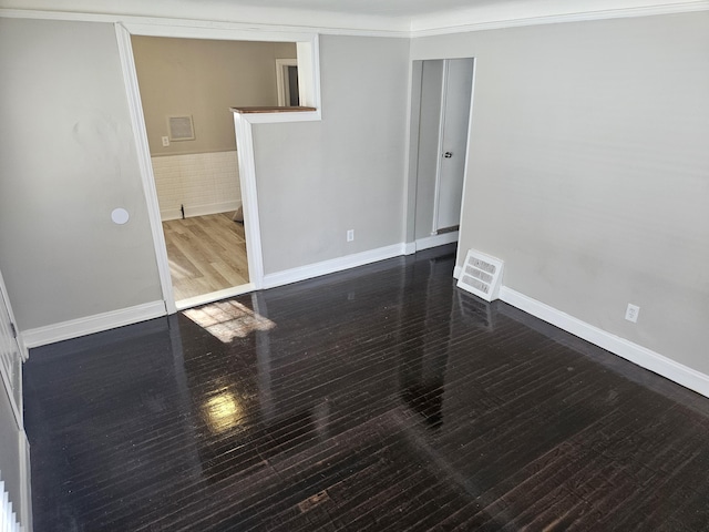 unfurnished room with dark wood-type flooring and crown molding