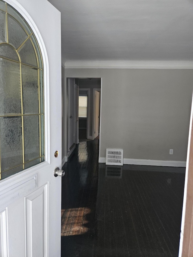 empty room with dark hardwood / wood-style flooring and ornamental molding