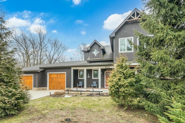 view of front of property featuring a porch, a front lawn, and a garage