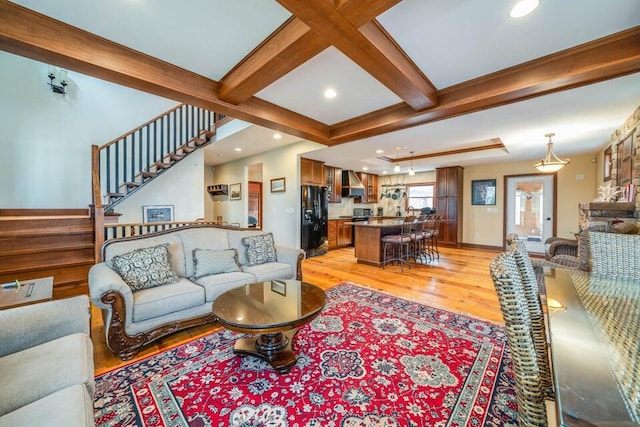 living room with coffered ceiling, beamed ceiling, and light hardwood / wood-style flooring