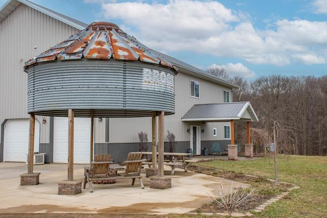 back of house featuring a patio, a garage, a yard, and a gazebo