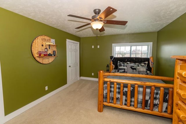 bedroom featuring a textured ceiling, ceiling fan, and light colored carpet