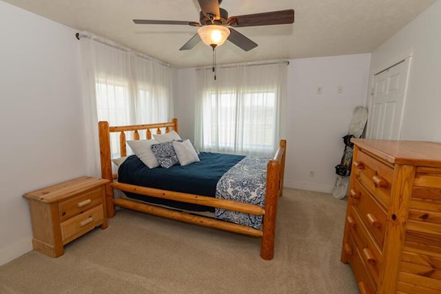 carpeted bedroom featuring ceiling fan and a closet