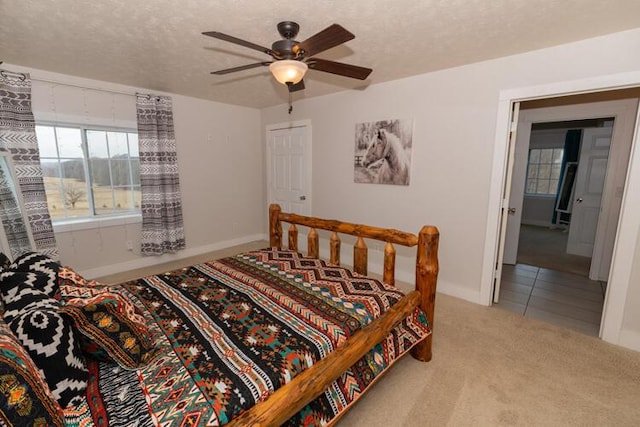 carpeted bedroom with a textured ceiling and ceiling fan