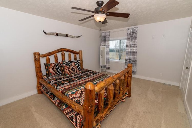 carpeted bedroom with a textured ceiling and ceiling fan