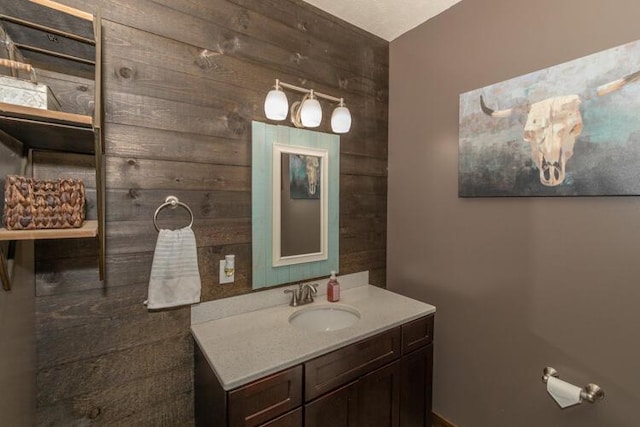 bathroom featuring wooden walls and vanity