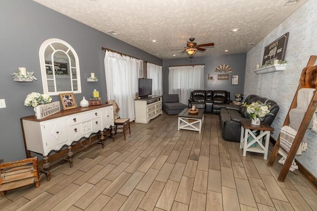 living room featuring a textured ceiling and ceiling fan