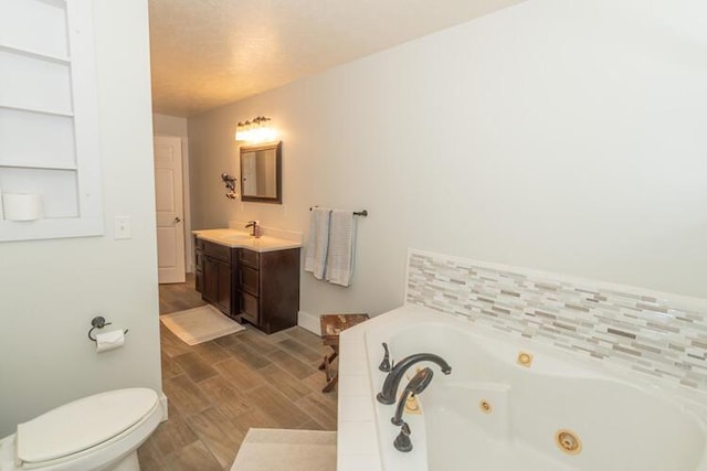 bathroom featuring hardwood / wood-style floors, toilet, vanity, and a bathing tub