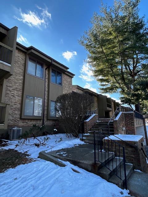 snow covered property with central air condition unit