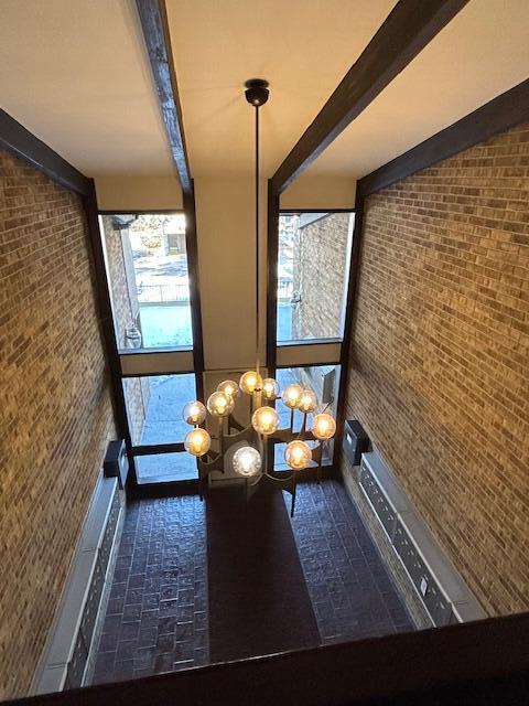 unfurnished dining area featuring a towering ceiling and beam ceiling