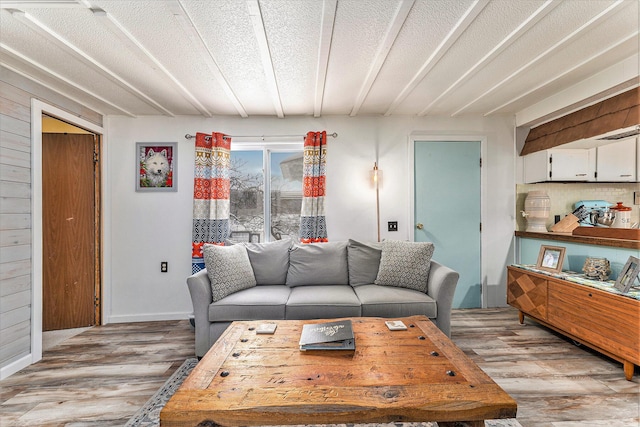 living room featuring wooden walls, a textured ceiling, and light hardwood / wood-style flooring