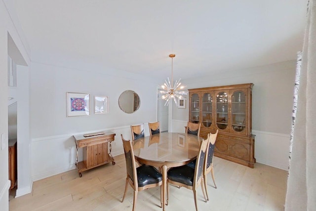 dining room featuring light hardwood / wood-style floors, an inviting chandelier, and ornamental molding