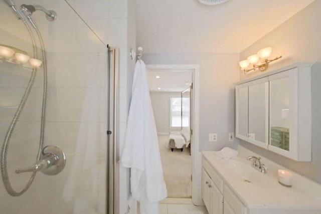 bathroom with an enclosed shower, vanity, and tile patterned flooring