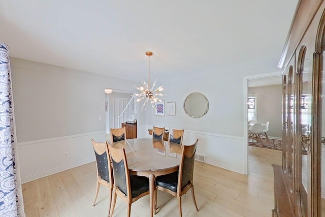 dining area with a notable chandelier and light hardwood / wood-style flooring