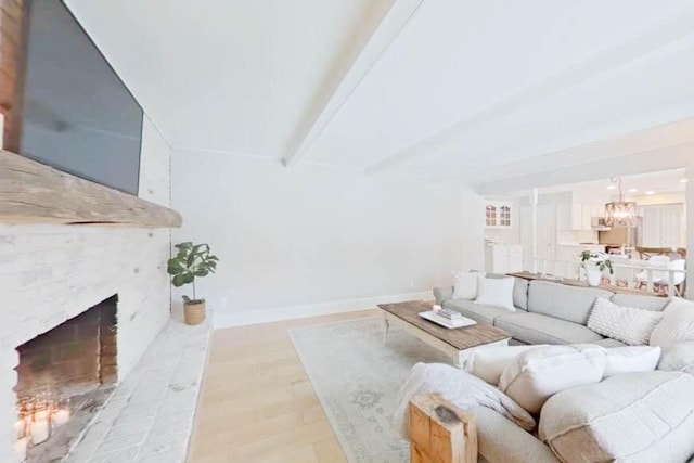 living room with a fireplace, light wood-type flooring, and beamed ceiling