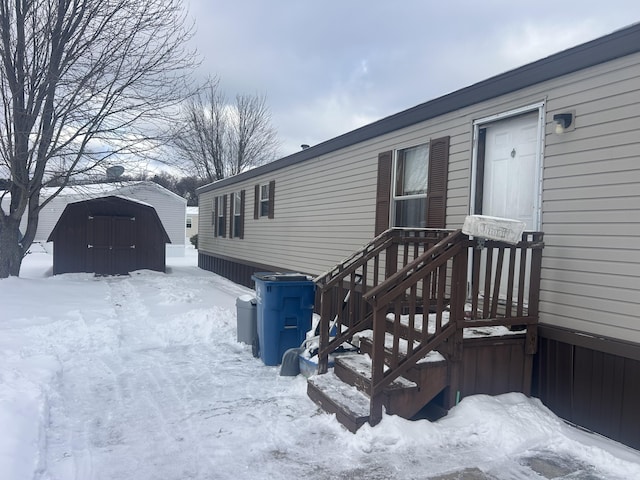 view of snow covered exterior featuring a storage shed