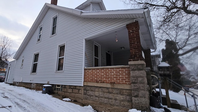 view of snow covered exterior featuring covered porch