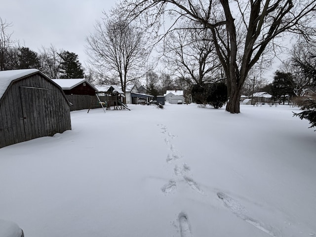 yard layered in snow with a storage unit