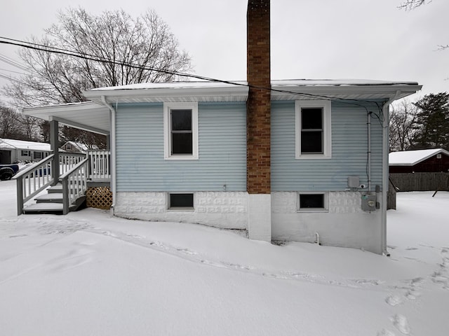 view of snow covered back of property