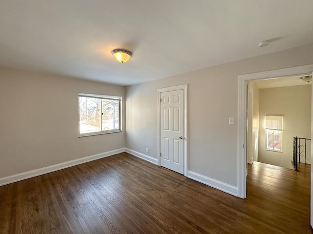 unfurnished bedroom with dark hardwood / wood-style flooring