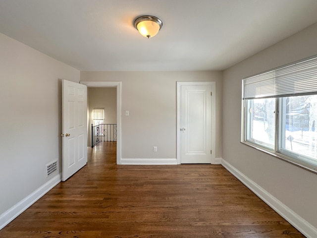 unfurnished room featuring dark wood-type flooring