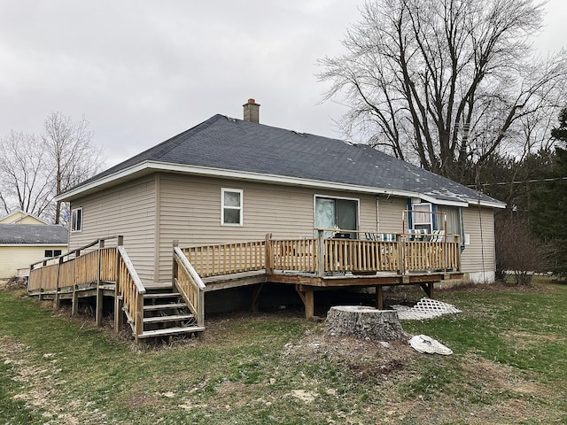 rear view of house featuring a lawn and a deck