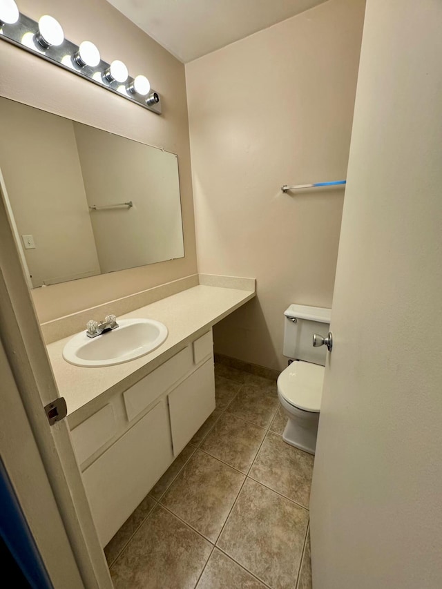 bathroom featuring toilet, tile patterned flooring, and vanity