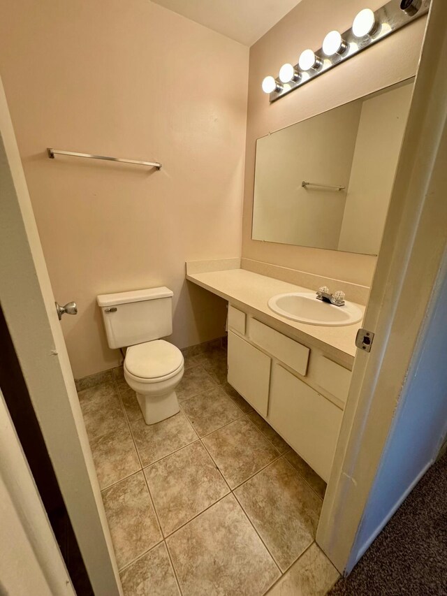 bathroom featuring tile patterned flooring, vanity, and toilet