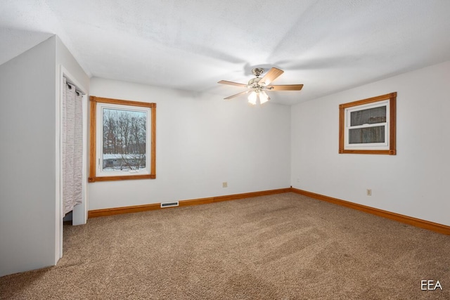 unfurnished room featuring ceiling fan and carpet