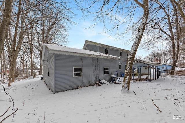 view of snow covered back of property