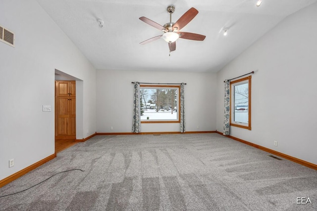 carpeted empty room with vaulted ceiling and ceiling fan