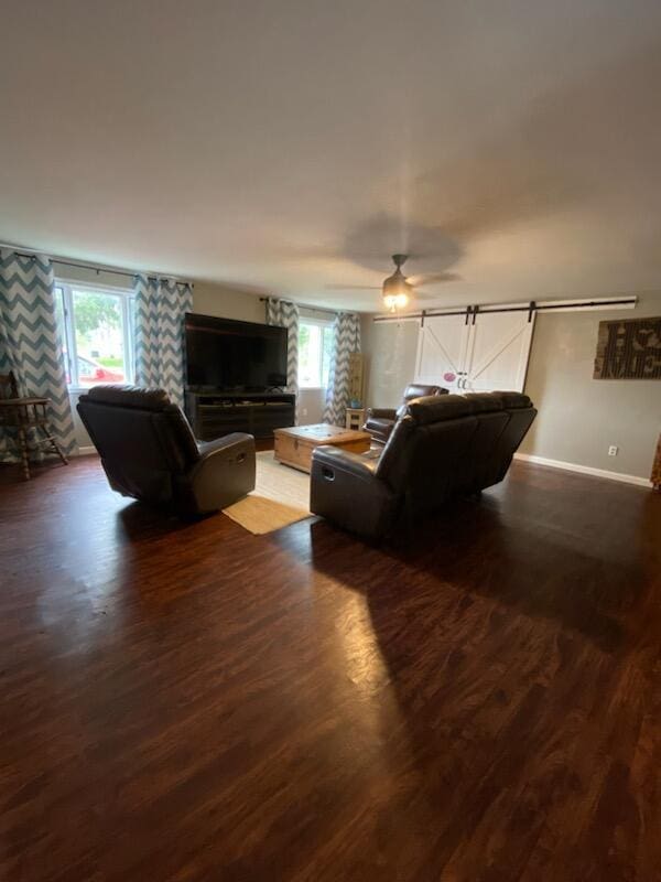 living room featuring a barn door and dark hardwood / wood-style floors