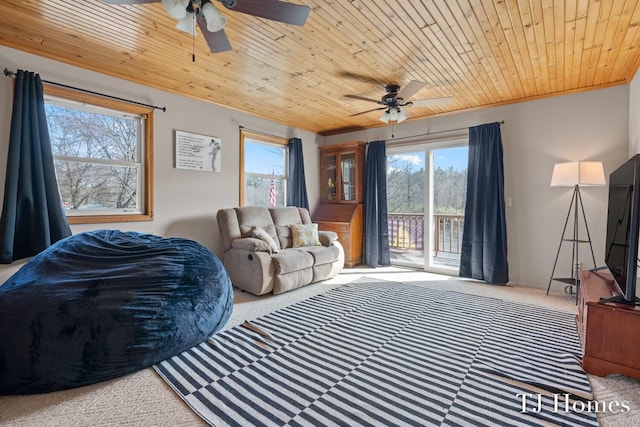 carpeted living room featuring crown molding, wooden ceiling, and ceiling fan