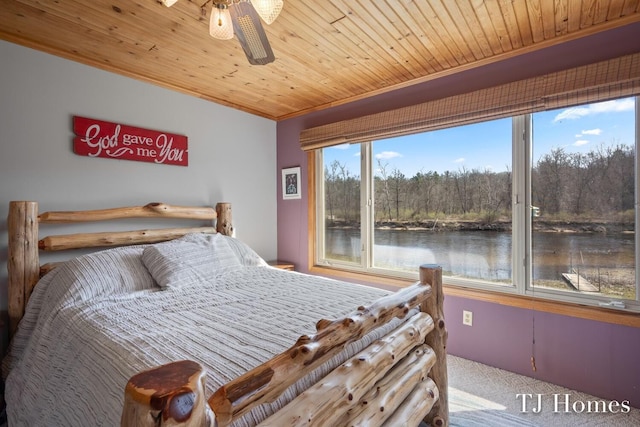 bedroom featuring ceiling fan, a water view, carpet floors, and wood ceiling