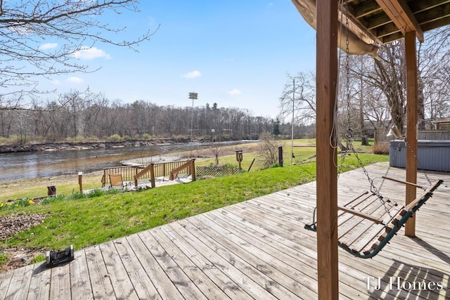 wooden terrace featuring a yard and a water view