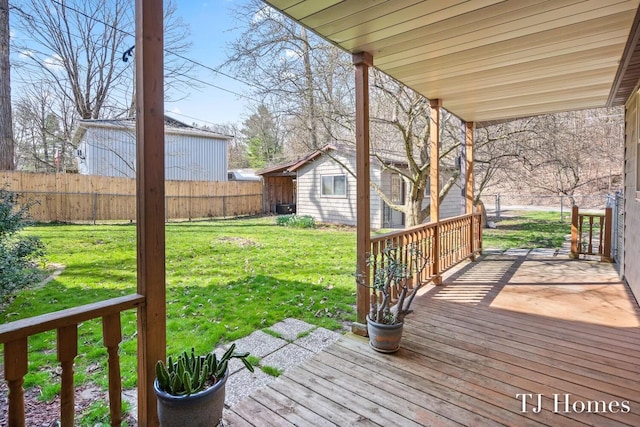 wooden deck featuring an outbuilding and a yard