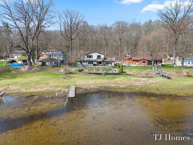 view of dock featuring a water view and a yard