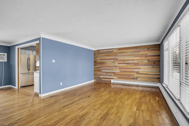 interior space with a baseboard radiator, wood walls, ornamental molding, and light hardwood / wood-style floors