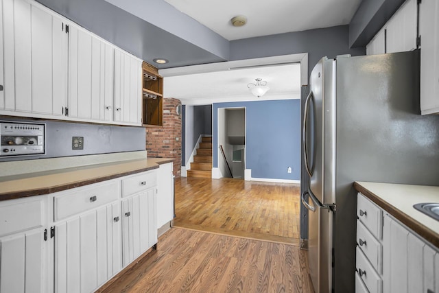 kitchen featuring white cabinets, stainless steel fridge, and hardwood / wood-style floors