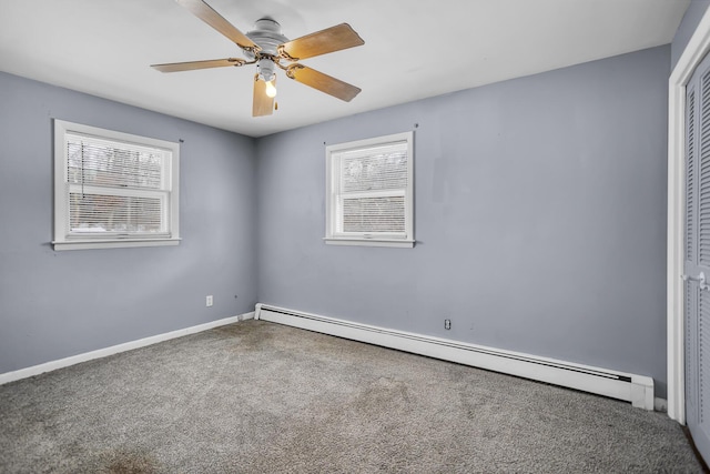 carpeted spare room featuring ceiling fan and a baseboard heating unit