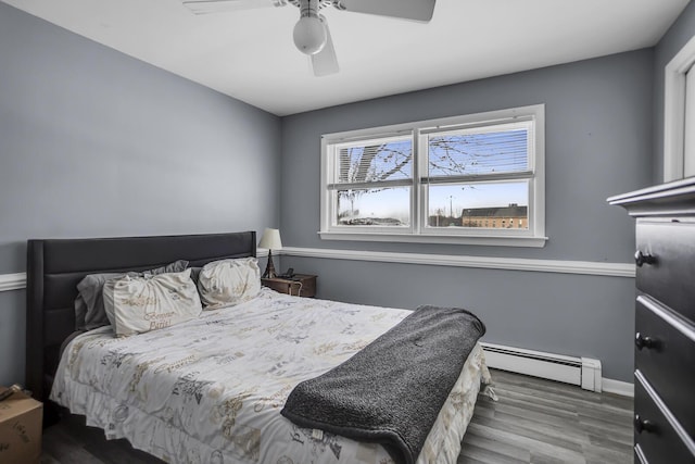 bedroom featuring wood-type flooring, a baseboard radiator, and ceiling fan