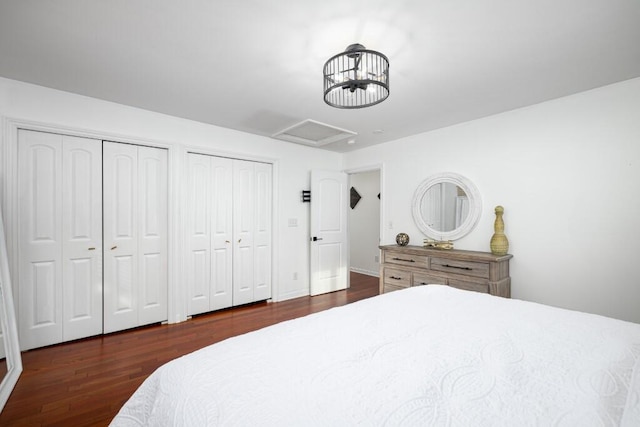 bedroom featuring dark hardwood / wood-style flooring and multiple closets