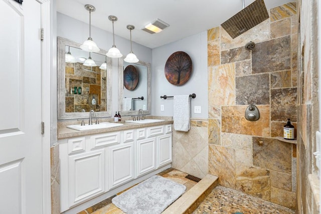 bathroom featuring a tile shower, tile walls, and vanity