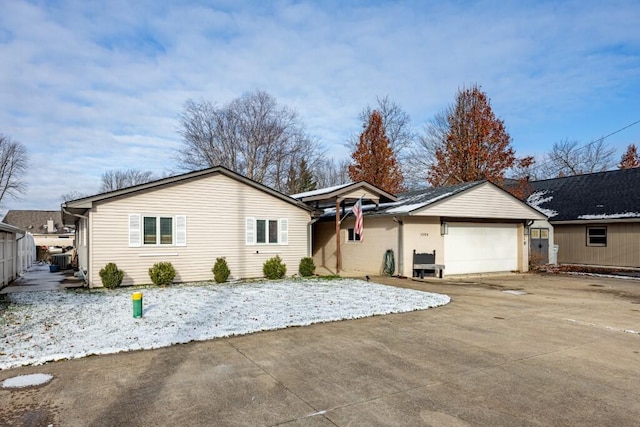 ranch-style house featuring a garage and central AC