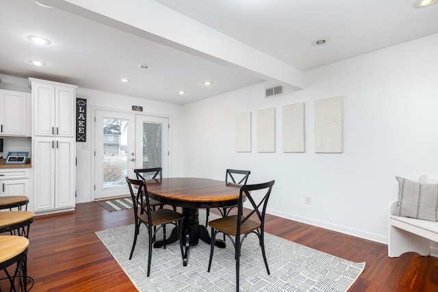 dining space with beam ceiling, dark hardwood / wood-style floors, and french doors