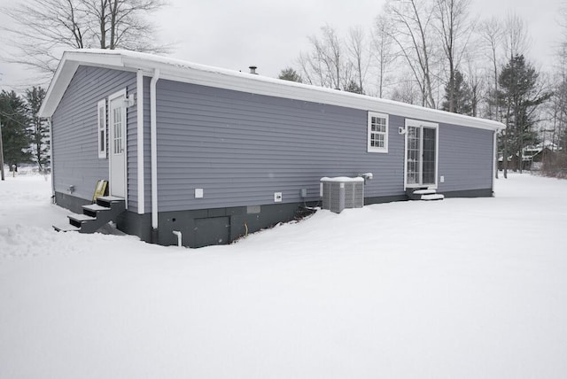 snow covered property featuring central AC unit