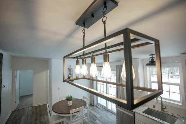 interior details with sink, dark hardwood / wood-style flooring, dishwasher, and light stone counters